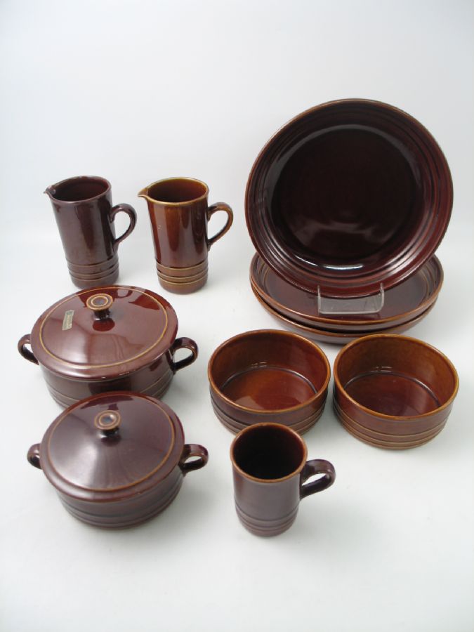 Matservisdelar, RUSTIK, Britt-Louise Sundell för Gustavsberg, 1970-tal, 10 del, 3 x uppläggningsfat, 2 x tillbringare, 2 x skål, 1 x katrull med lock, 1 x mindre kastrull med lock, 1 x mugg (?), ugnseldfast, brun glasyr, randdekor i godset, diameter uppläggningsfat: 31 cm, märkt: GUSTAVSBERG UGNSSÄKERT RUSTIK VDN S555 MADE IN SWEDEN, originaletikett på en av kastrullerna: GUSTAVSBERG Glasyrspricksäkert